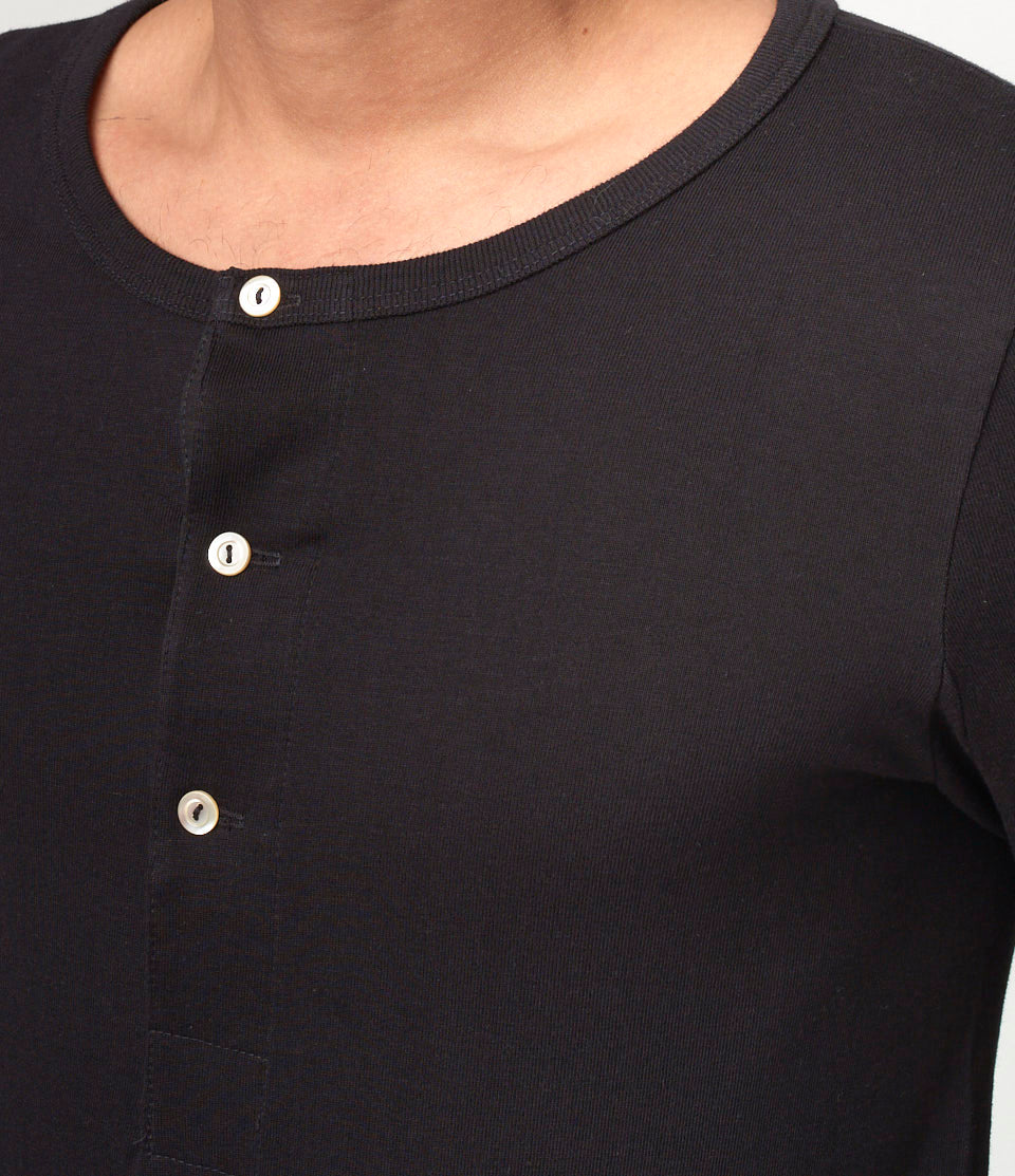 Close-up of a black shirt with buttons on a plain background
