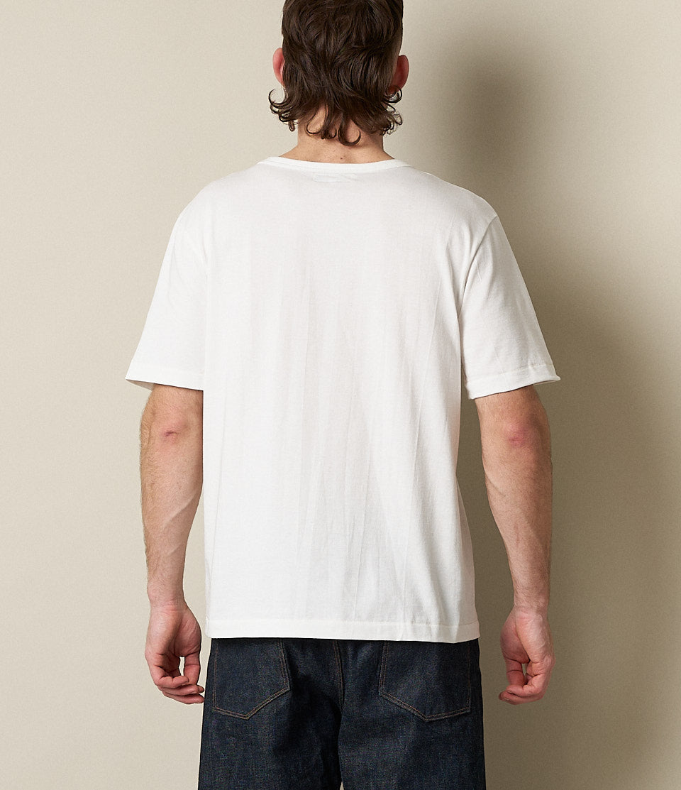 Person wearing a white t-shirt against a plain background