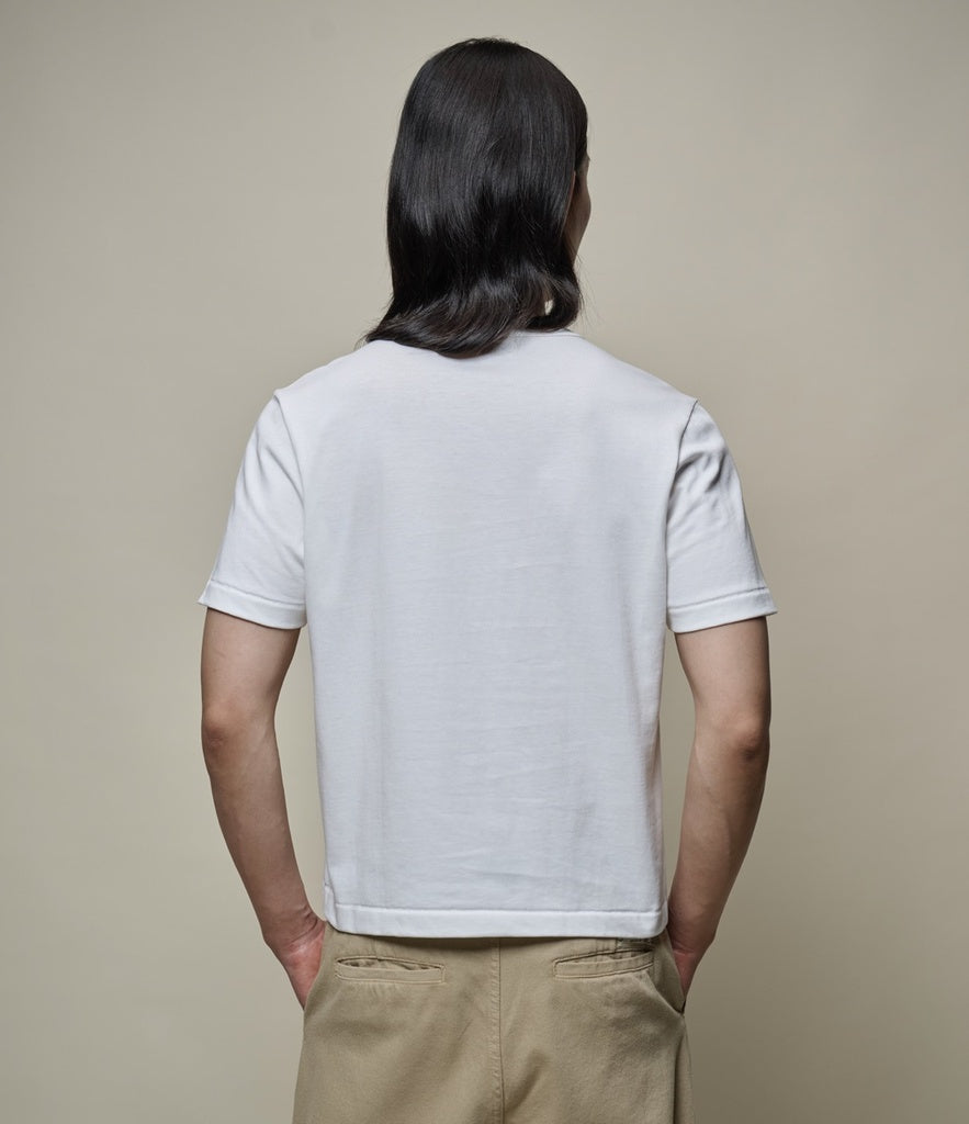 Man wearing cropped white T-shirt from behind