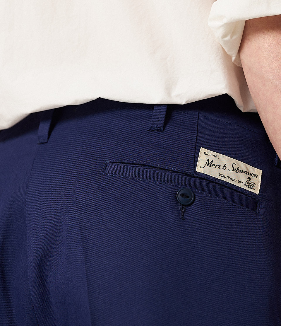 Close-up of navy blue pants with a brand label.