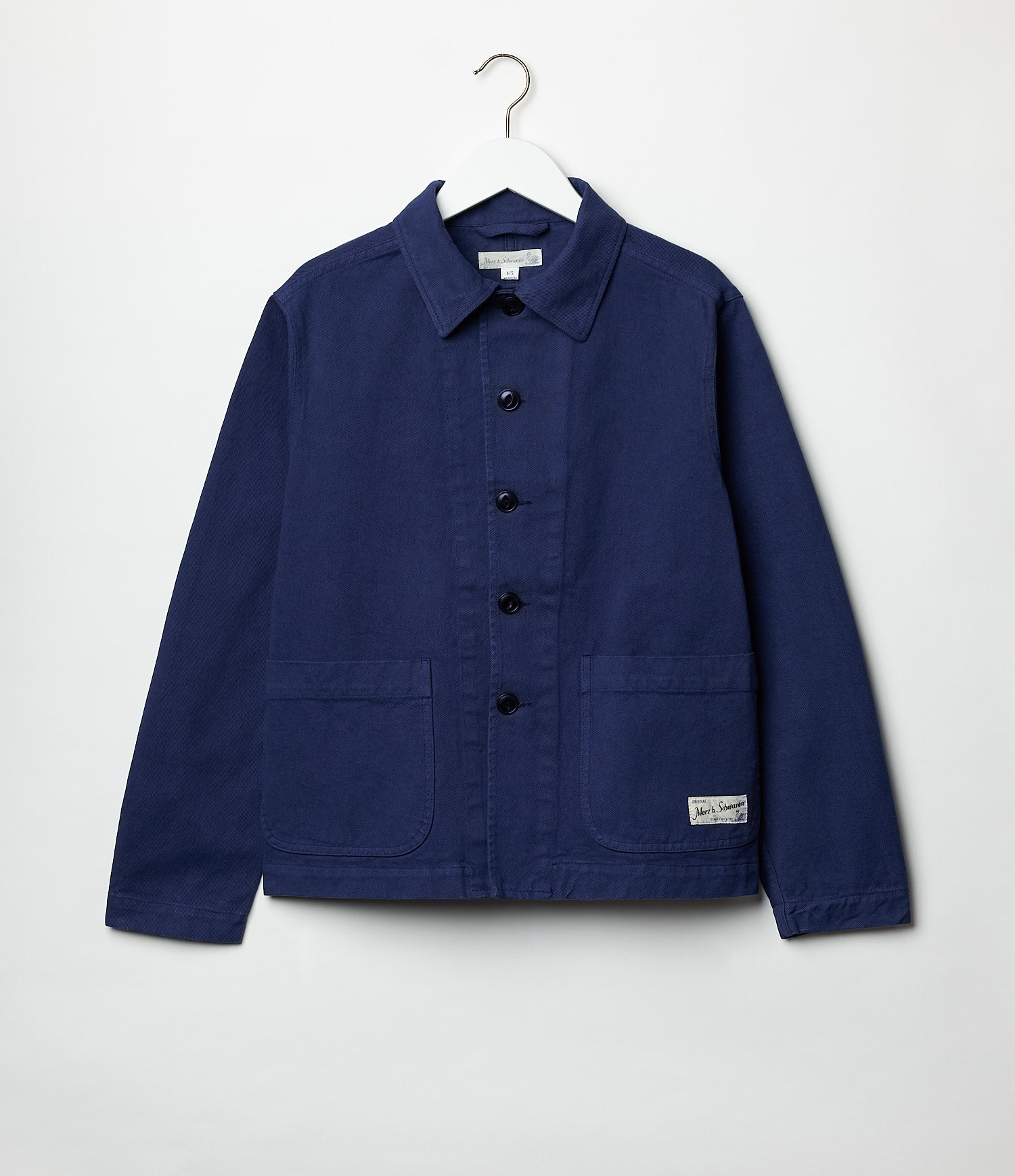 A cropped cotton twill jacket in blue, with a collar, button-up front, and two front pockets, displayed on a white background.
