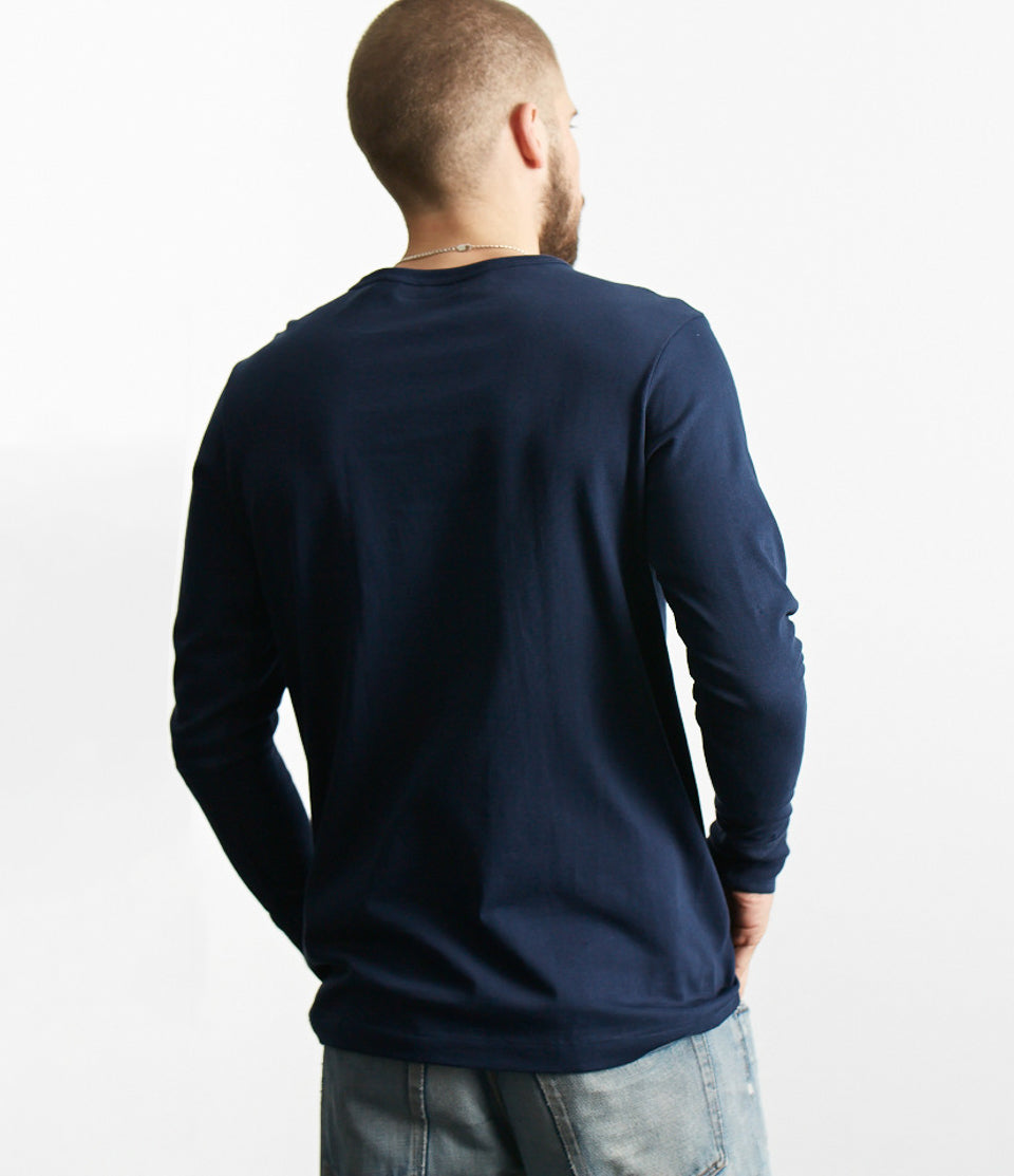 Person wearing a navy blue long-sleeve shirt against a white background.