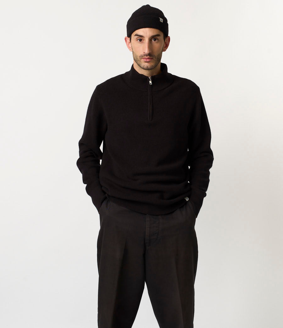 Man wearing a black sweater and pants with a black cap on a white background