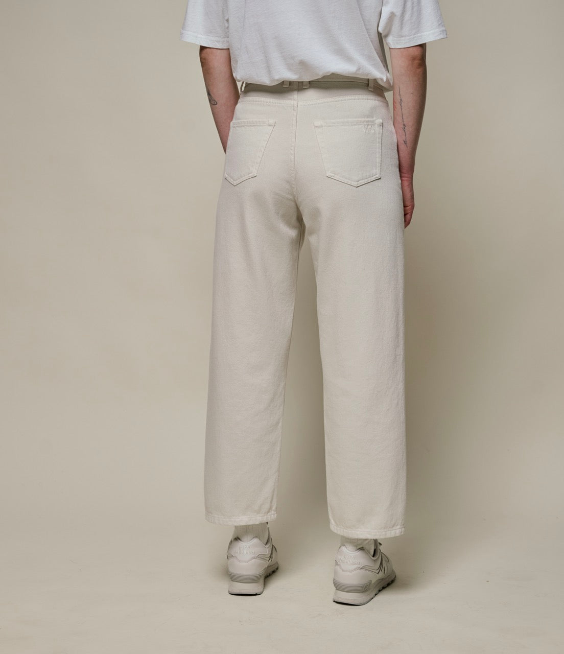Person wearing beige pants and white T-shirt from the back