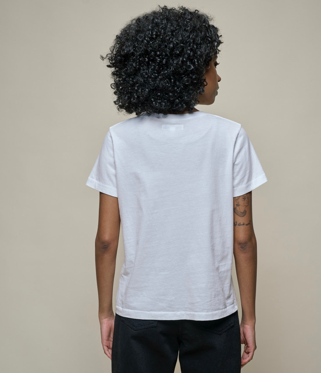 Person wearing a white t-shirt against a plain background