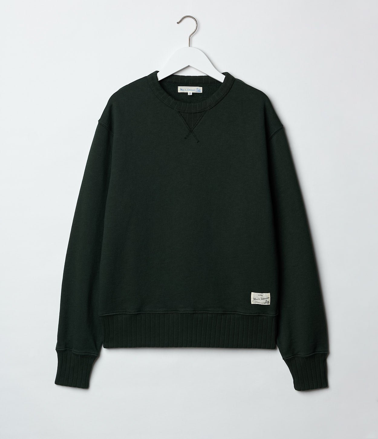 Green sweatshirt on a hanger against a white background