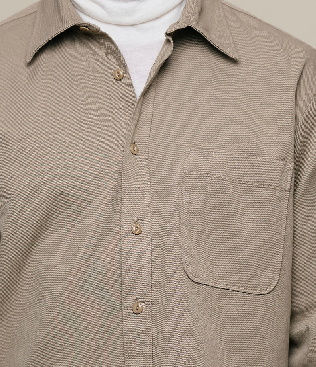 Beige shirt with a pocket on a plain background