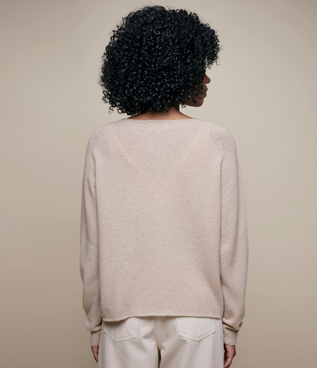 Person wearing a beige sweater and pants set.