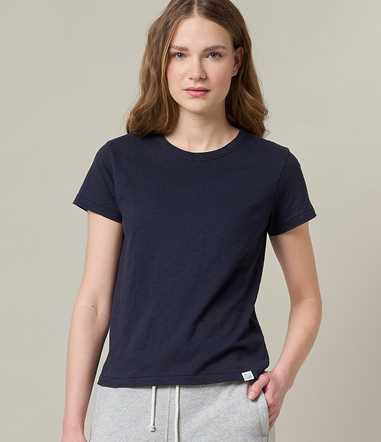 A woman wearing a navy blue T-shirt with short sleeves, made from pima cotton fabric.