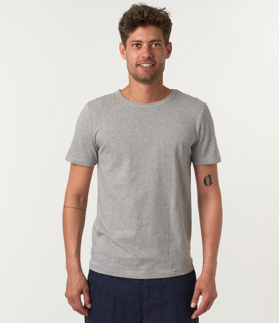 A man wearing a gray loopwheeled, short-sleeved, round-neck T-shirt.