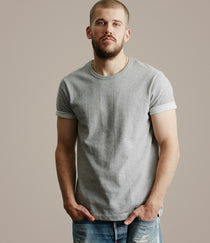 Man wearing a plain gray t-shirt against a neutral background