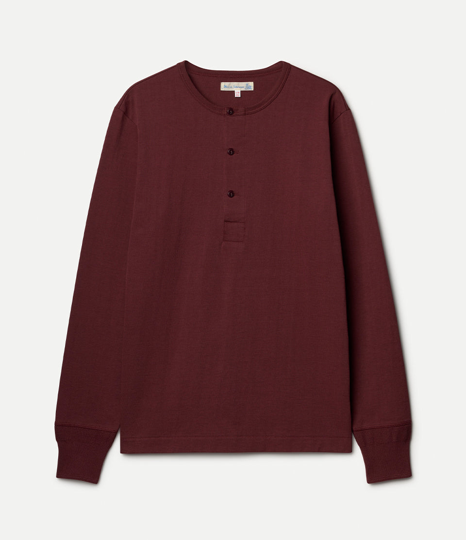 Burgundy long-sleeve henley shirt on a light gray background