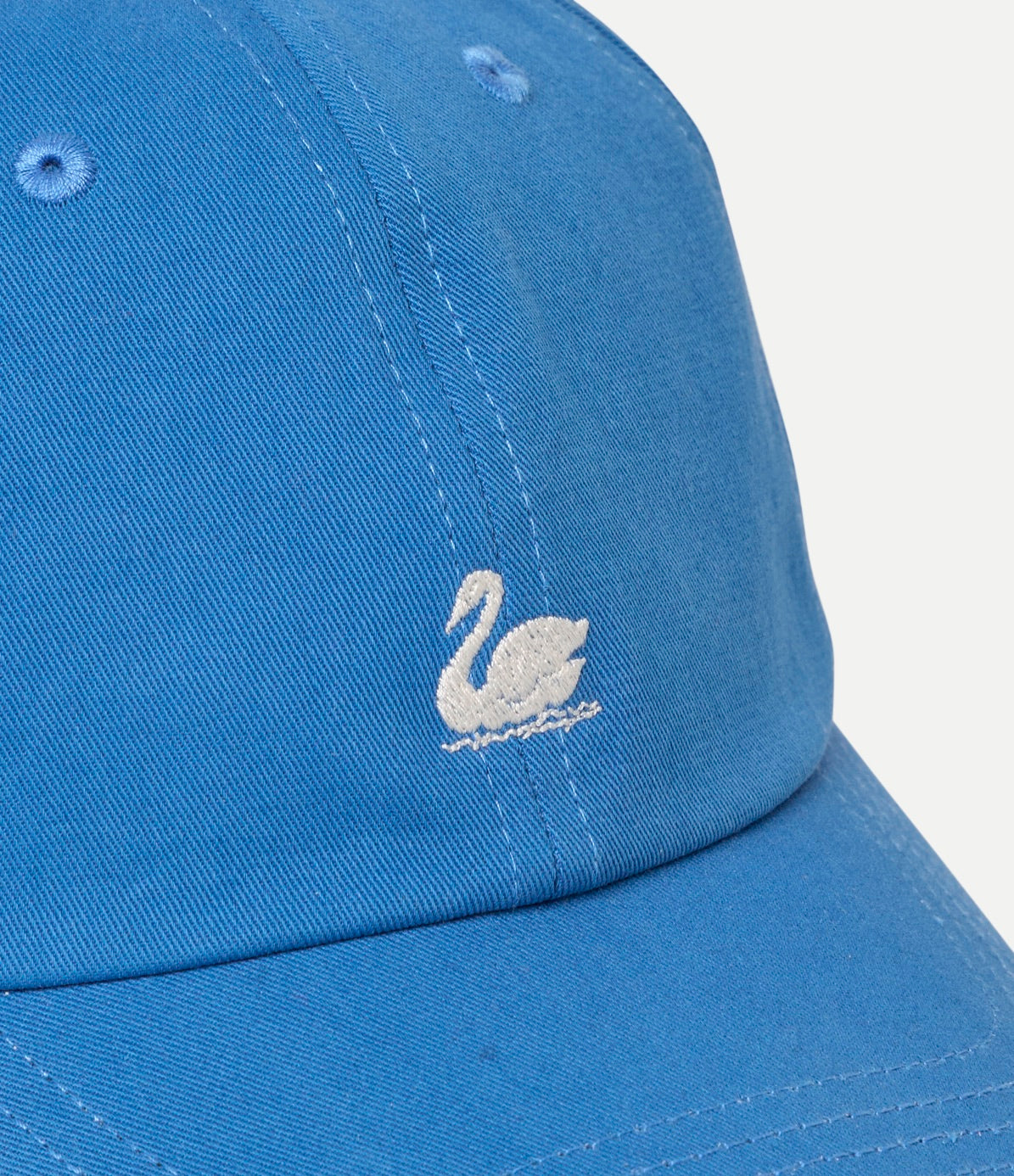 Blue cap with a white embroidered swan logo on a light gray background