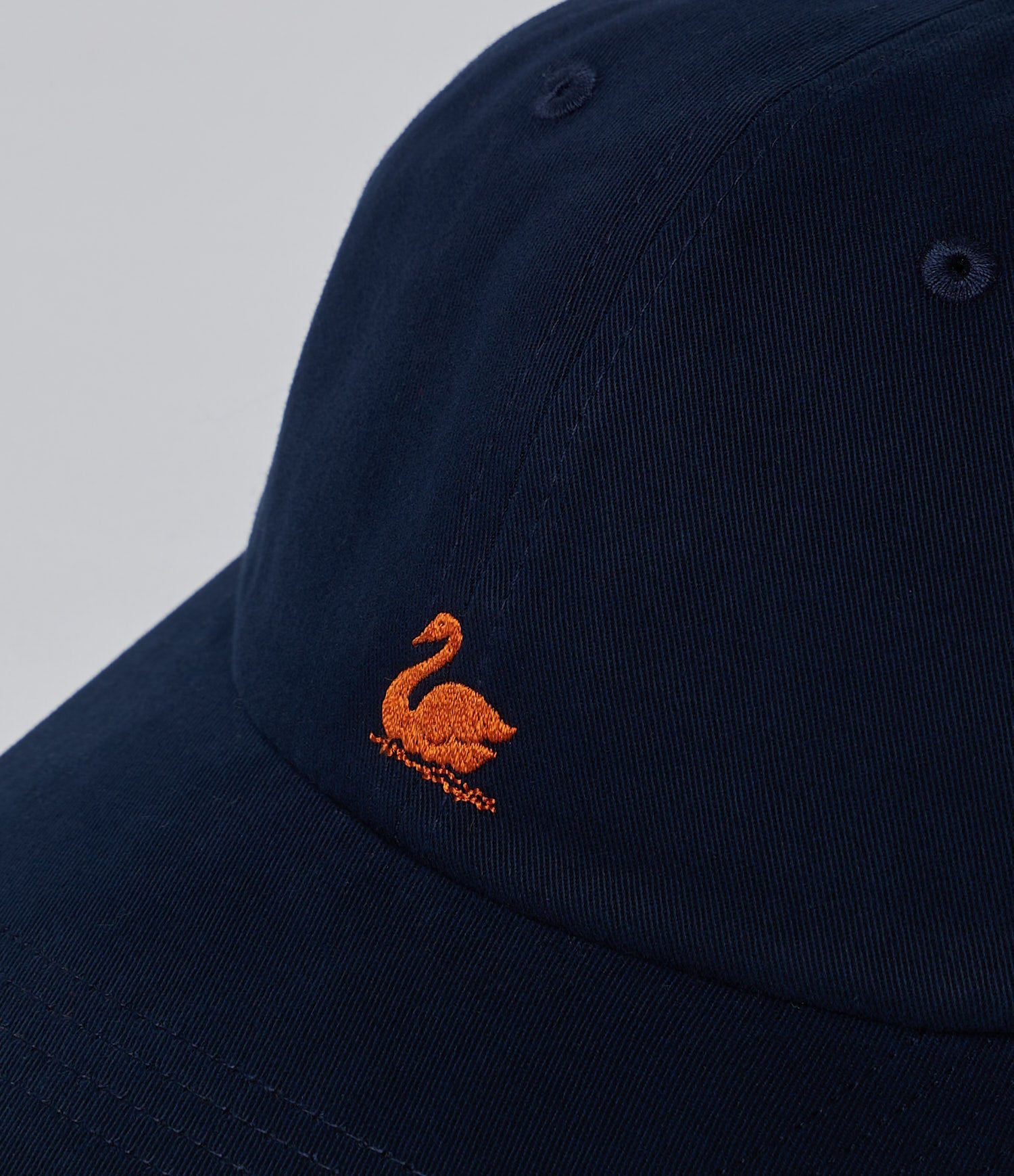 Blue cap with orange embroidered swan logo on a light gray background
