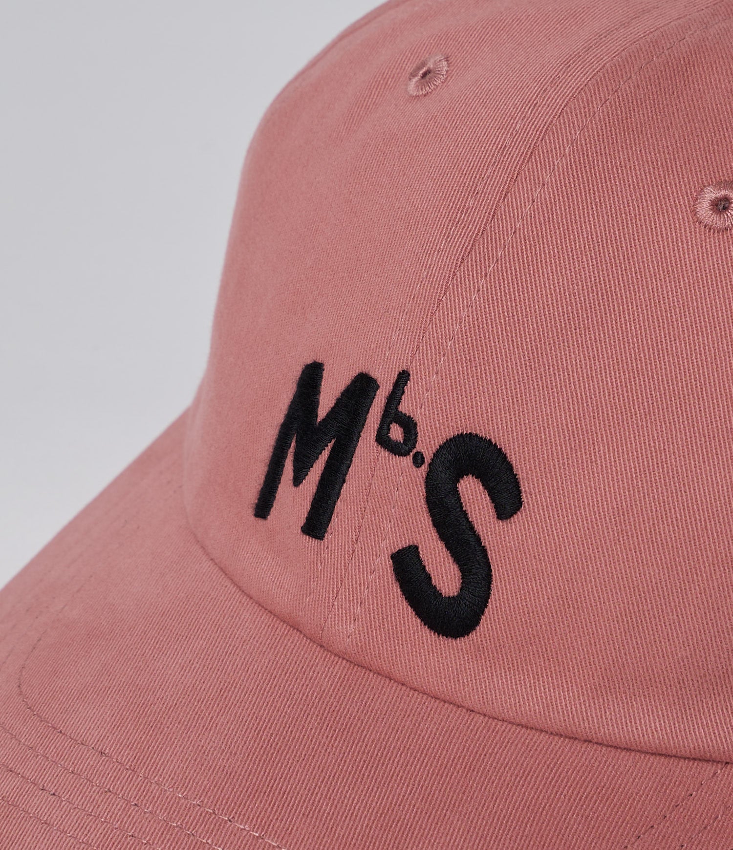 Pink cap with black 'MbS' logo on a light gray background