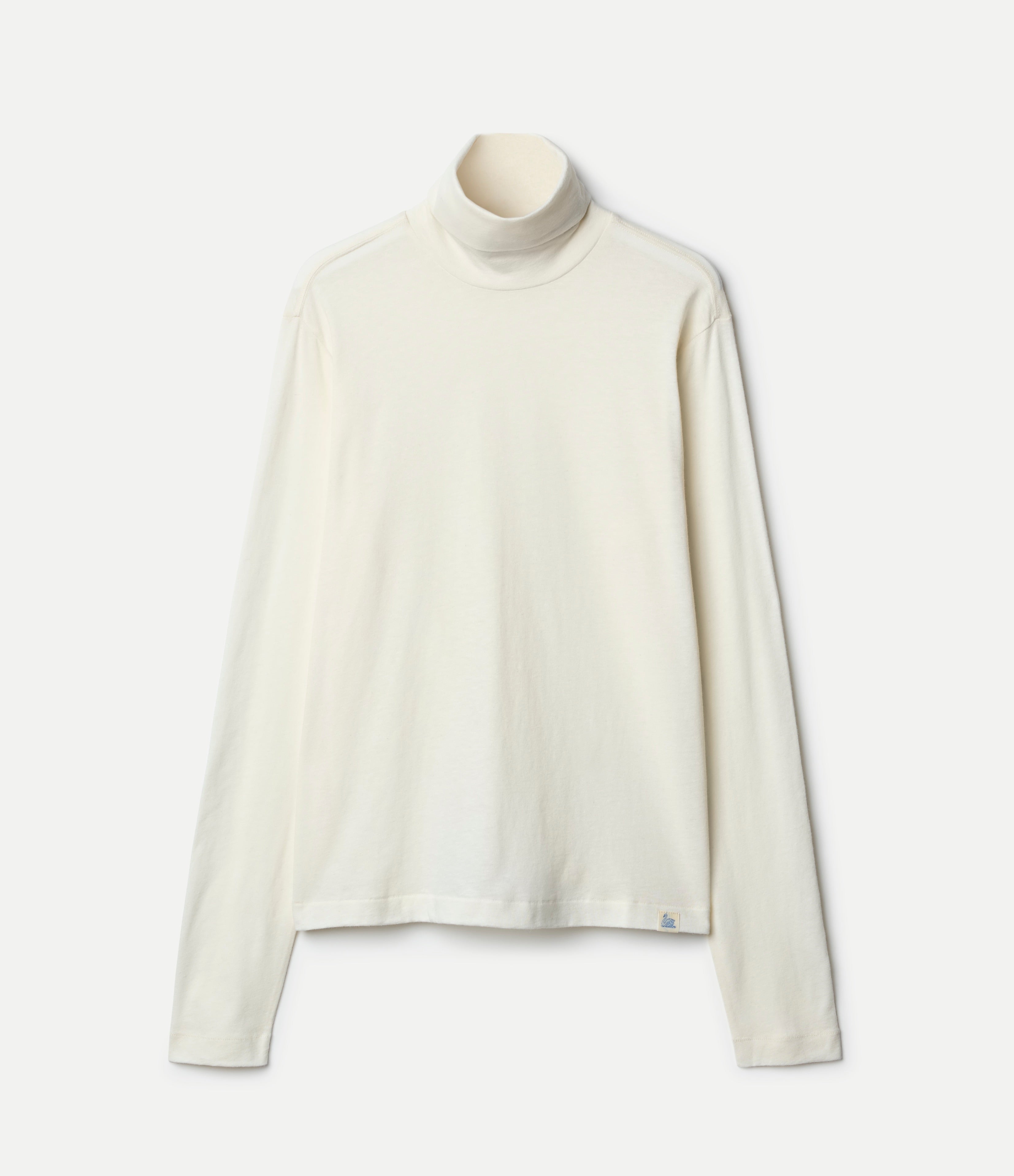 Beige cashmere turtleneck longsleeve shirt against neutral background