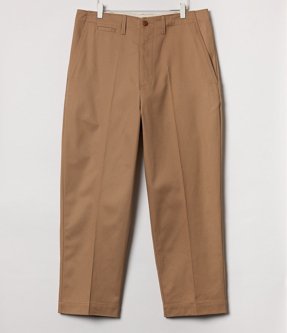 Beige pants hanging against a white background