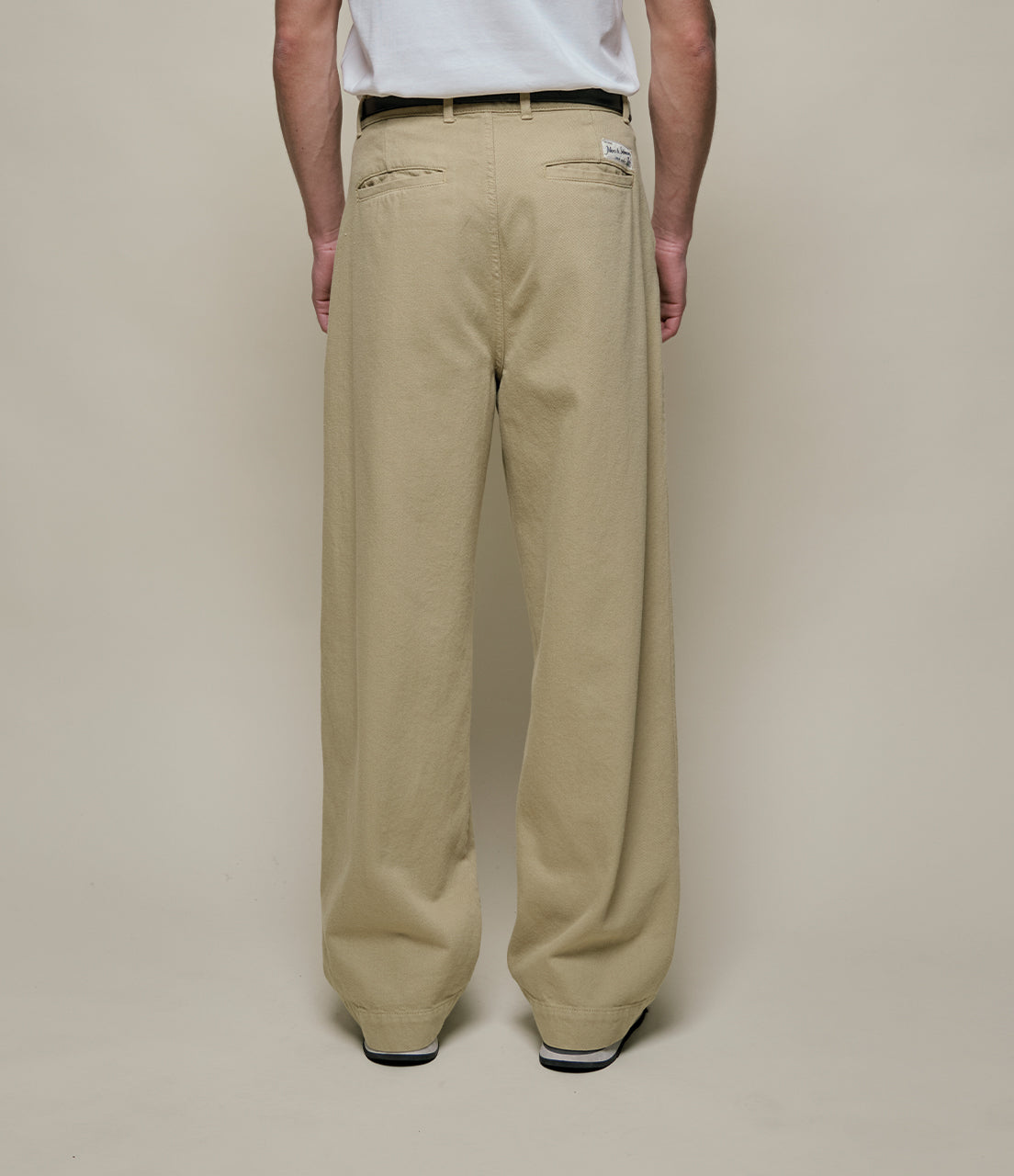 Beige pants worn by a person on a plain background
