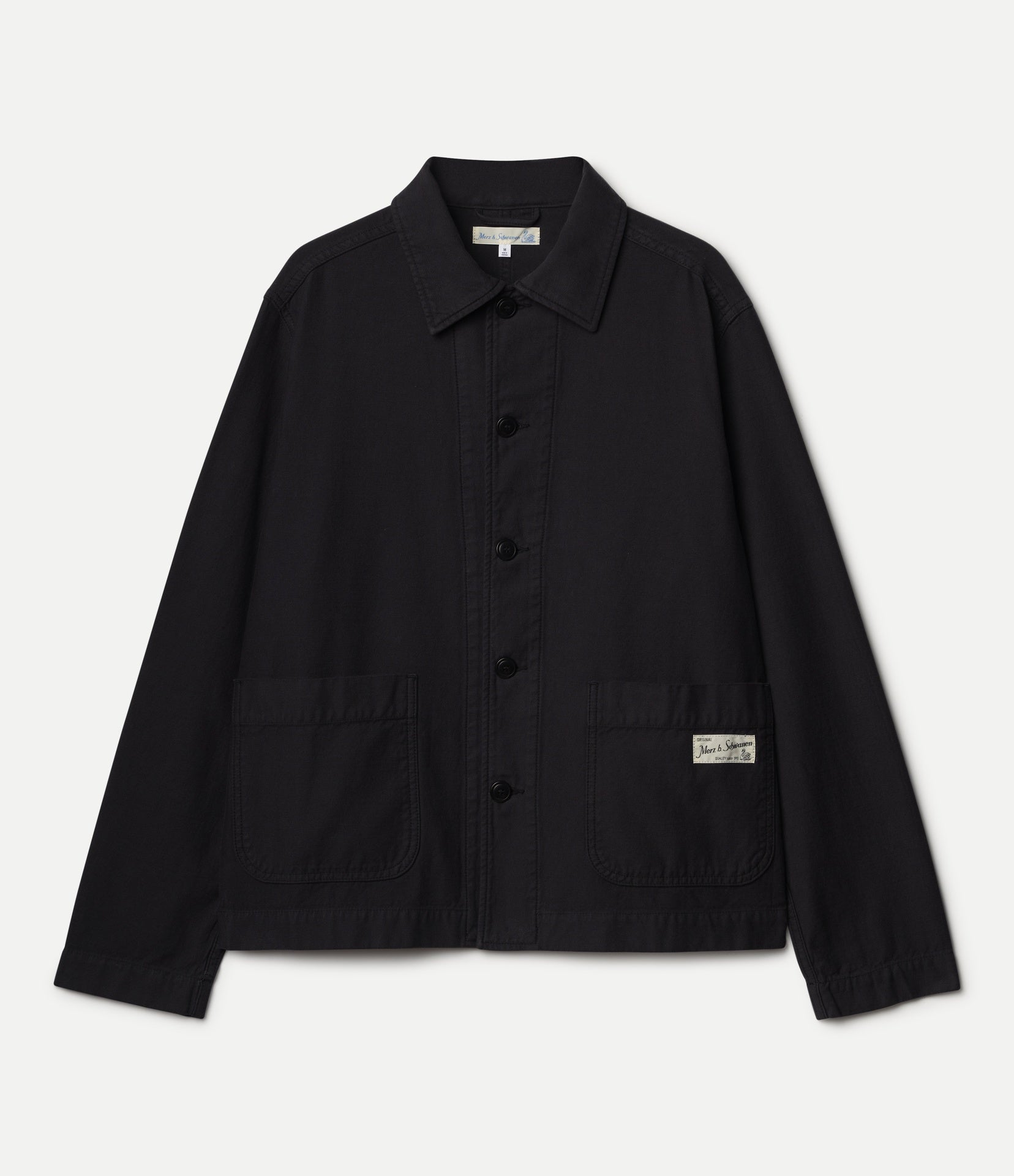 A black utility jacket with a pointed collar, button-up front, and two front patch pockets, shown flat against a light gray background.