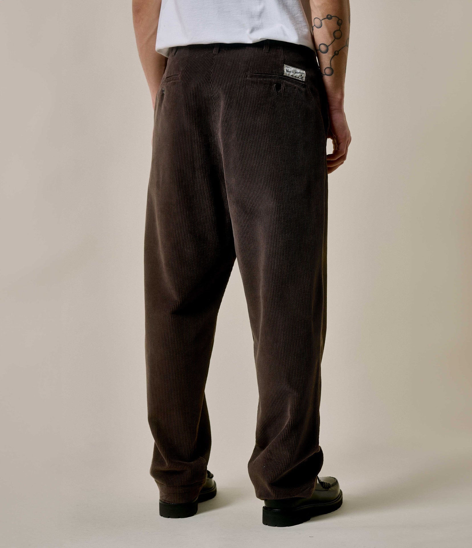 Brown pants worn by a person on a neutral background