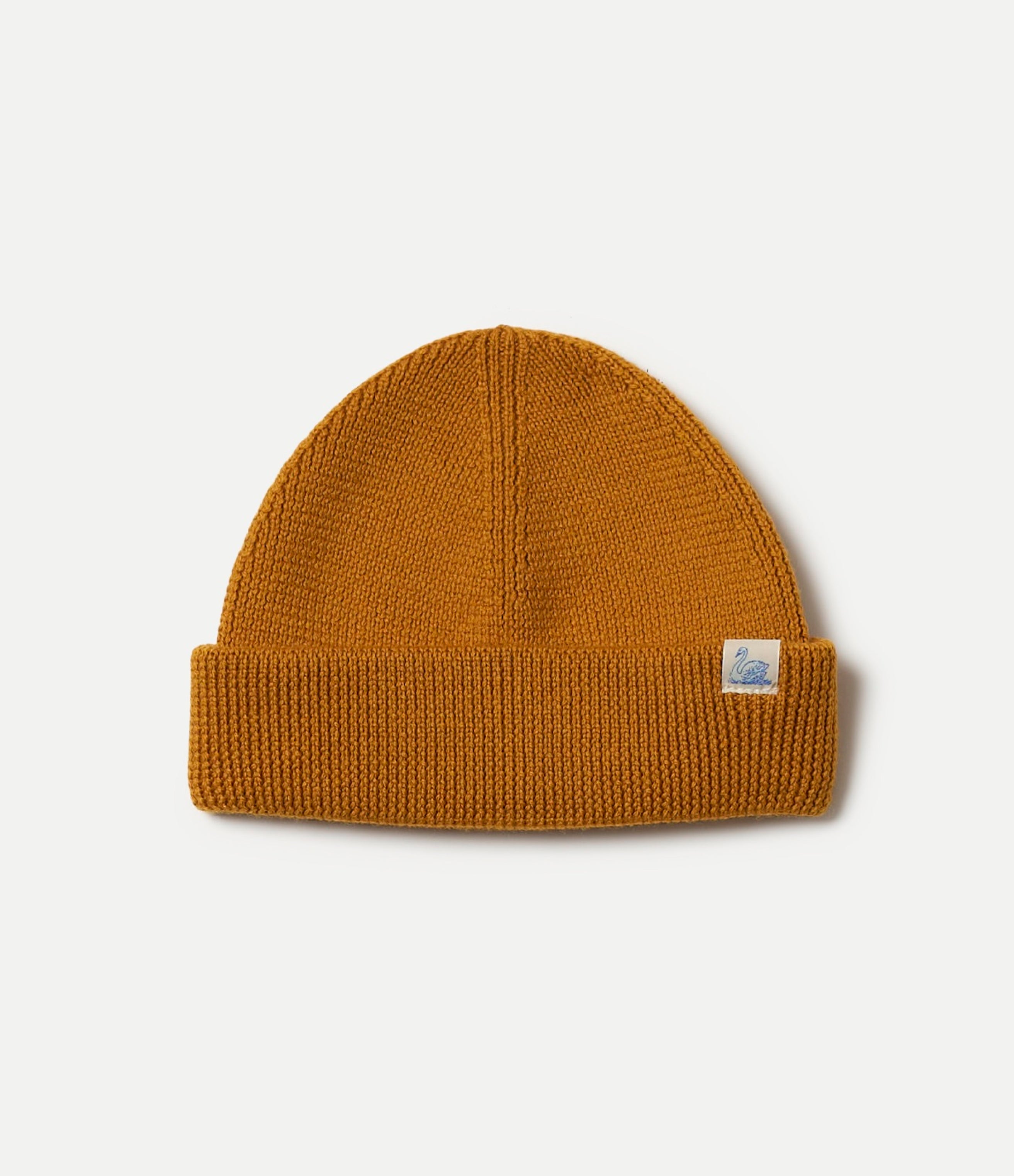 Honey Brown knit beanie with a Swan logo tag on a light gray background