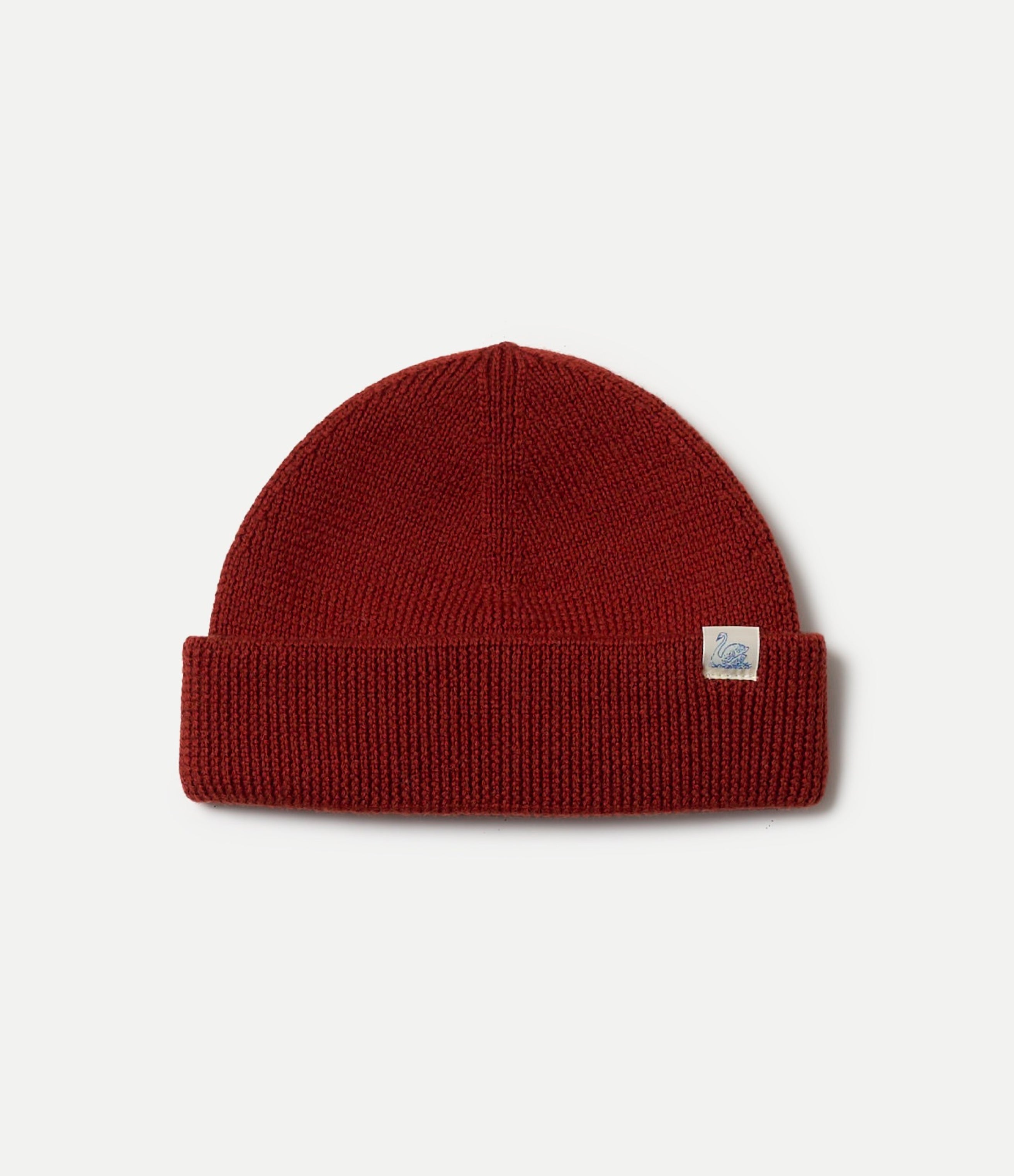 Red merino wool beanie with a  Swan brand logo on a light gray background