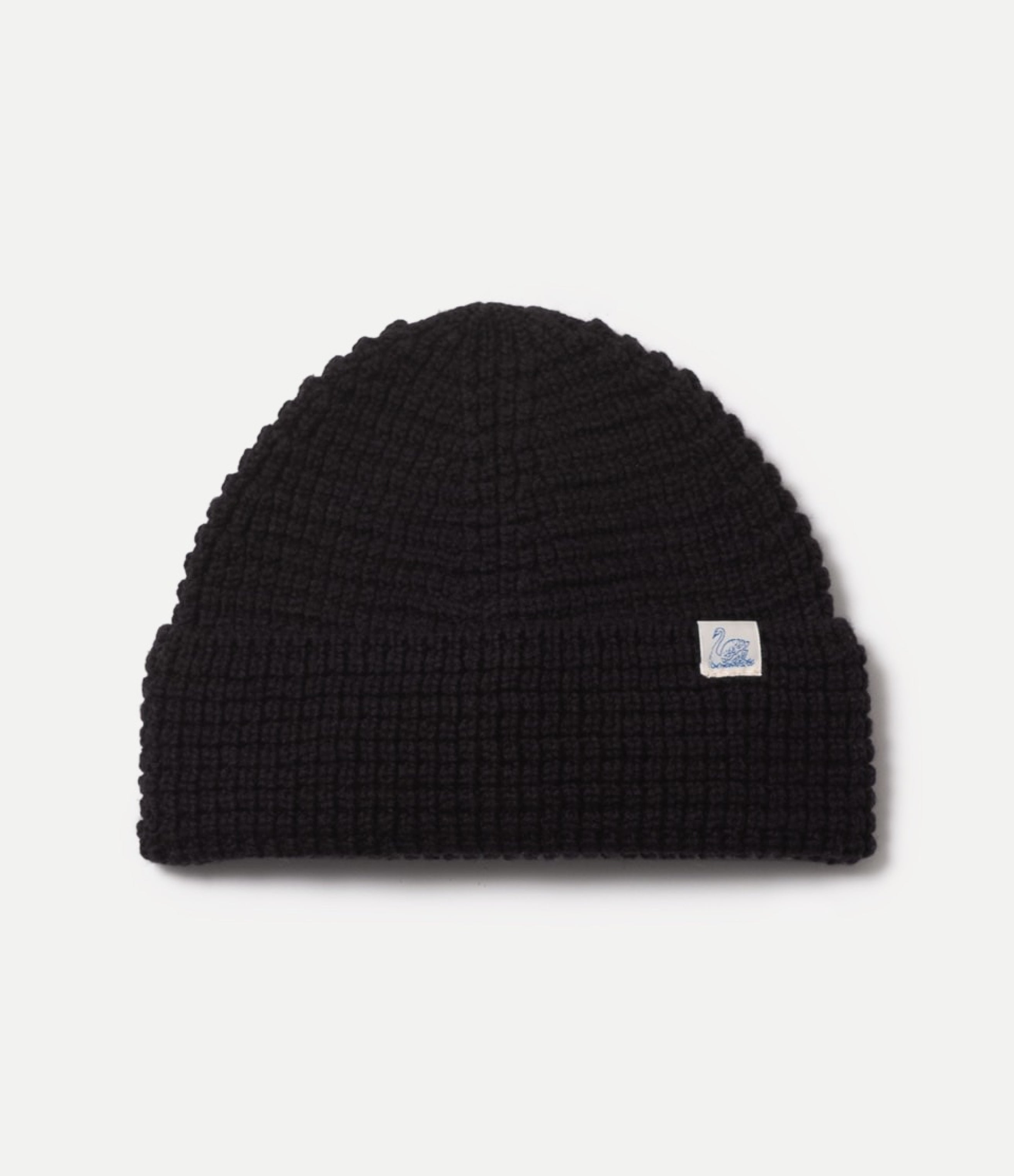 Black waffle knit beanie with a small logo on a light gray background