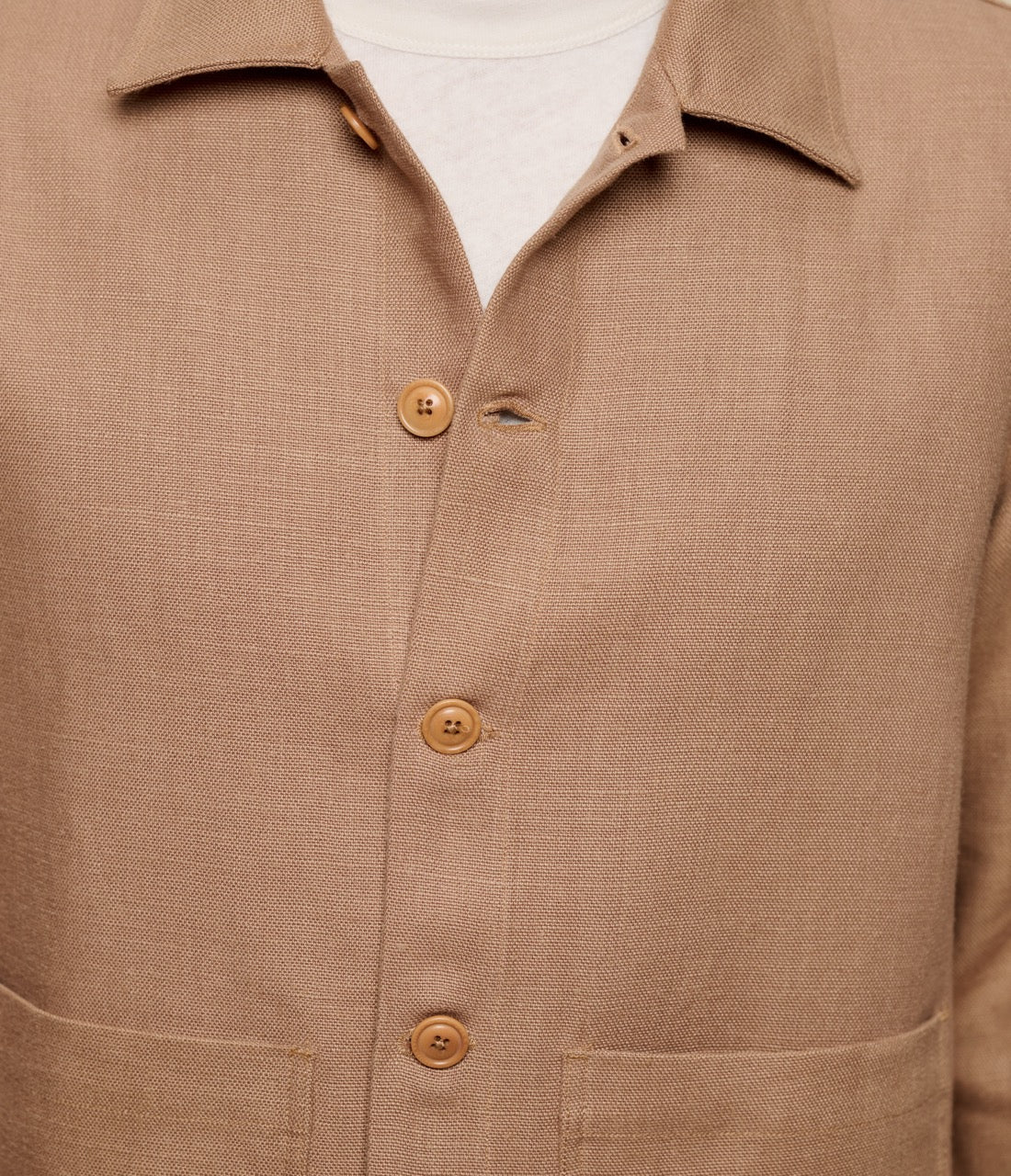 Close-up of a brown linen jacket with a white collar.