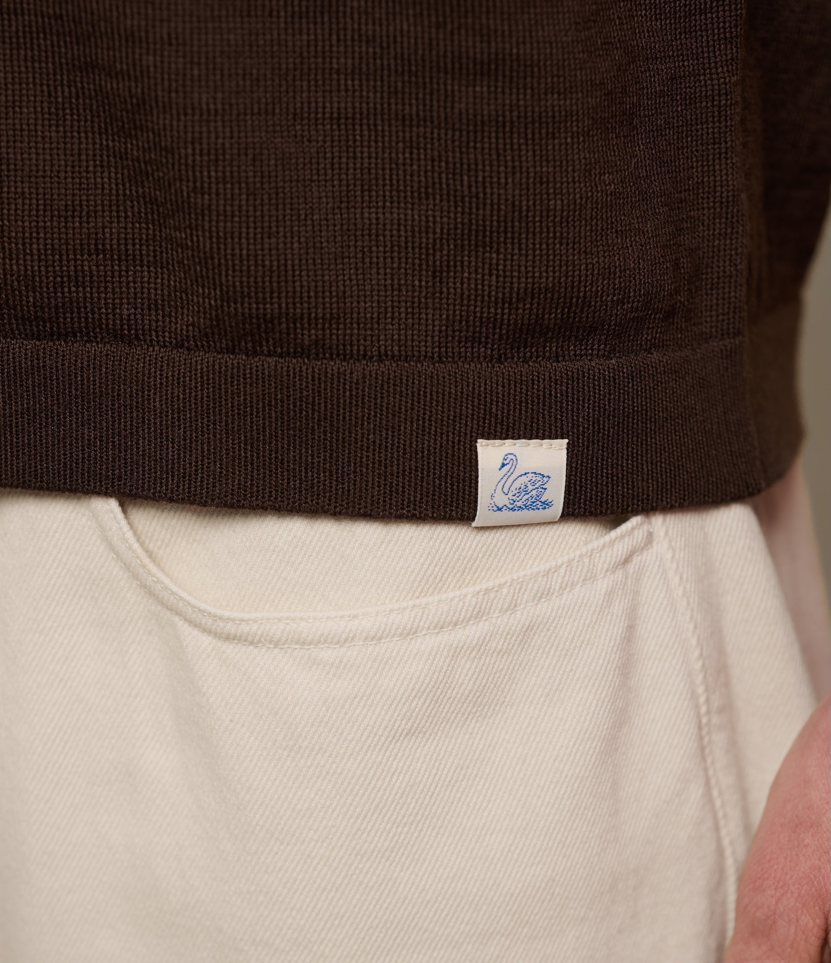 Close-up of a brown merino wool garment with a Merz b. Schwanen label.