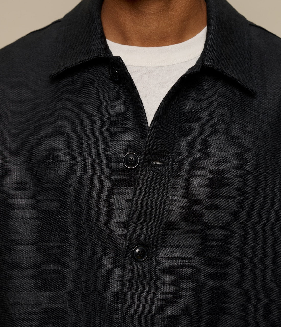 Close-up of a black linen jacket with a neutral background