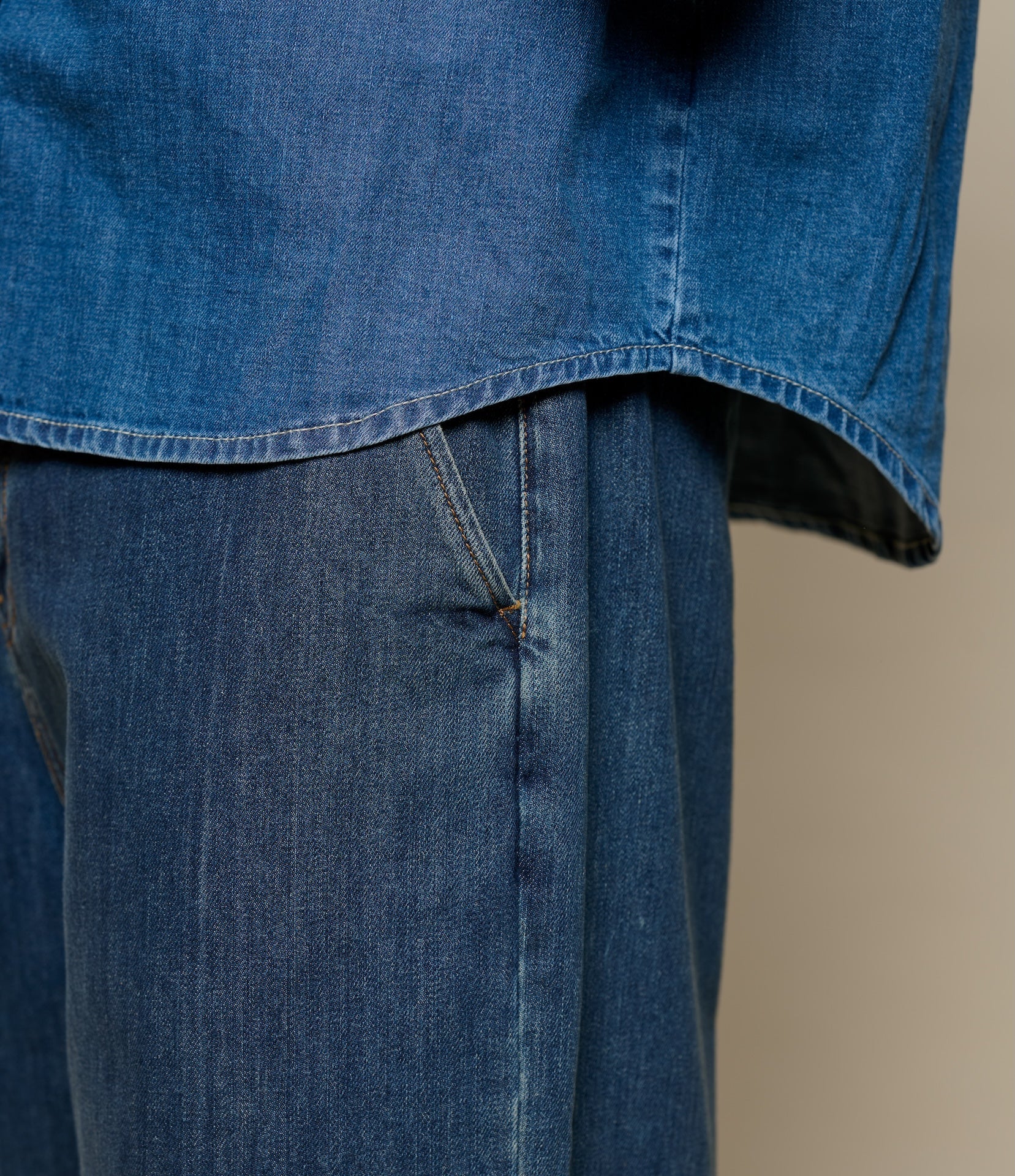 Close-up of blue denim fabric with a plain background
