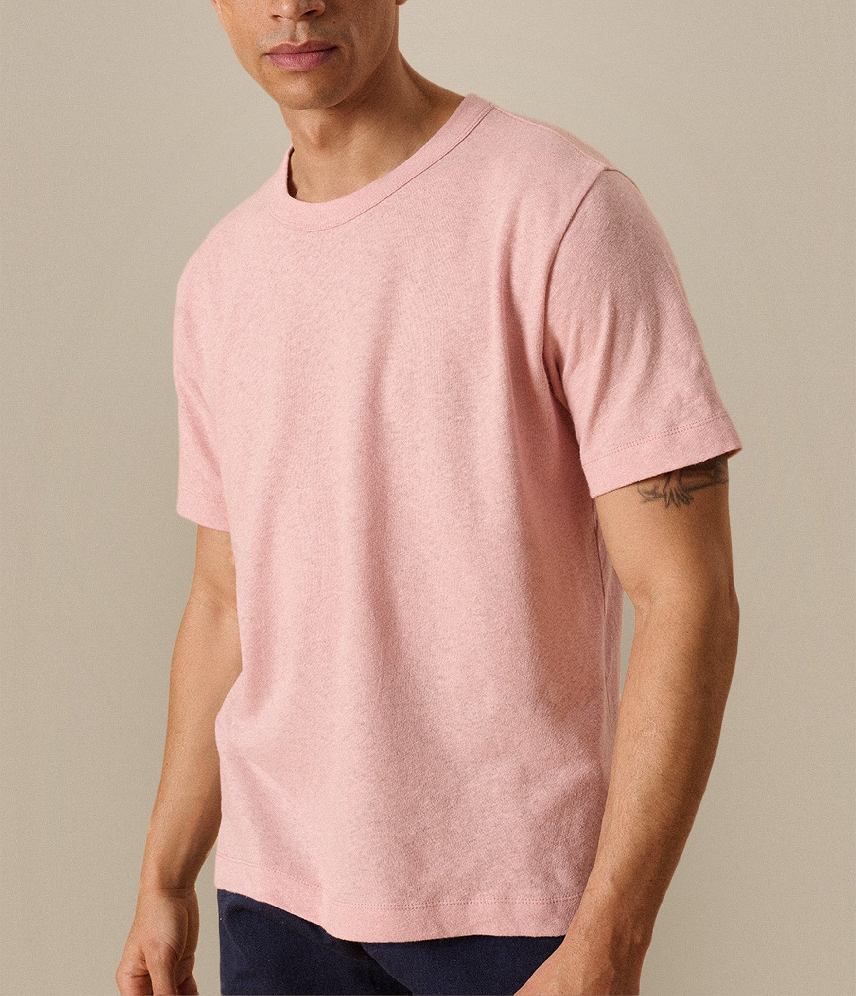 Man wearing a pink t-shirt against a beige background