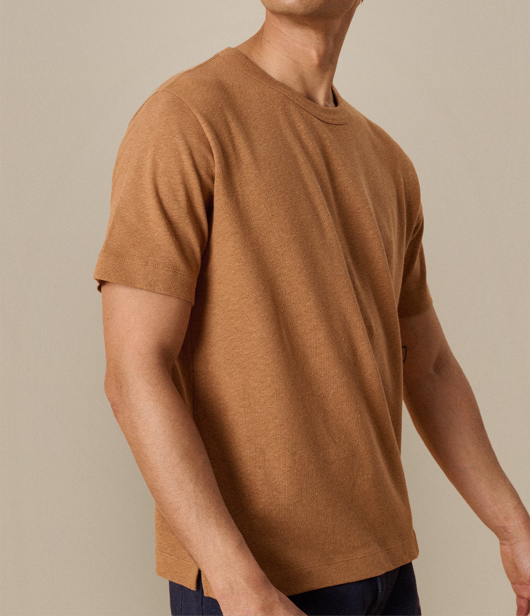 Man wearing a brown t-shirt against a beige background