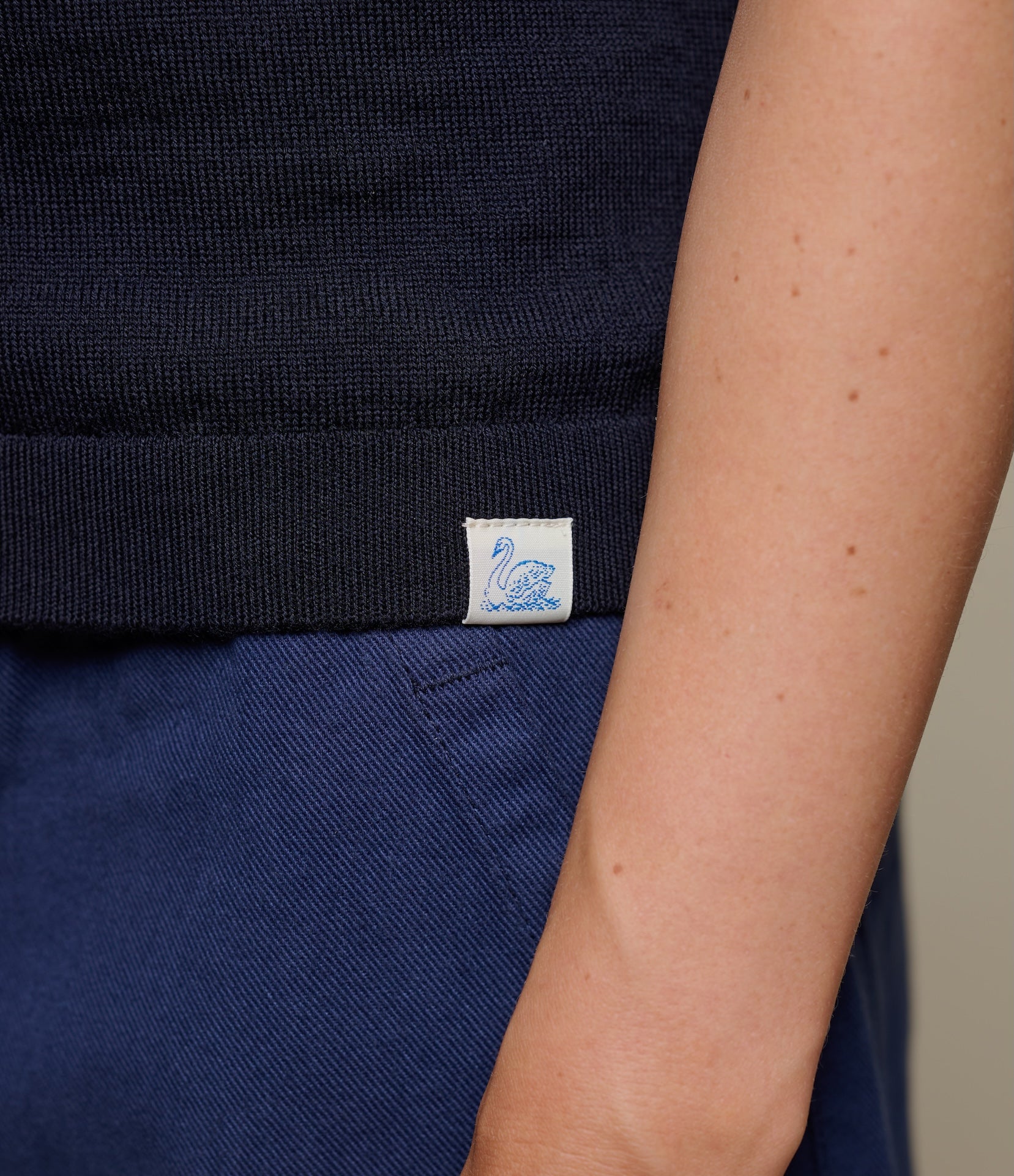 Navy blue merino wool garment with a Merz b. Schwanen label on a neutral background