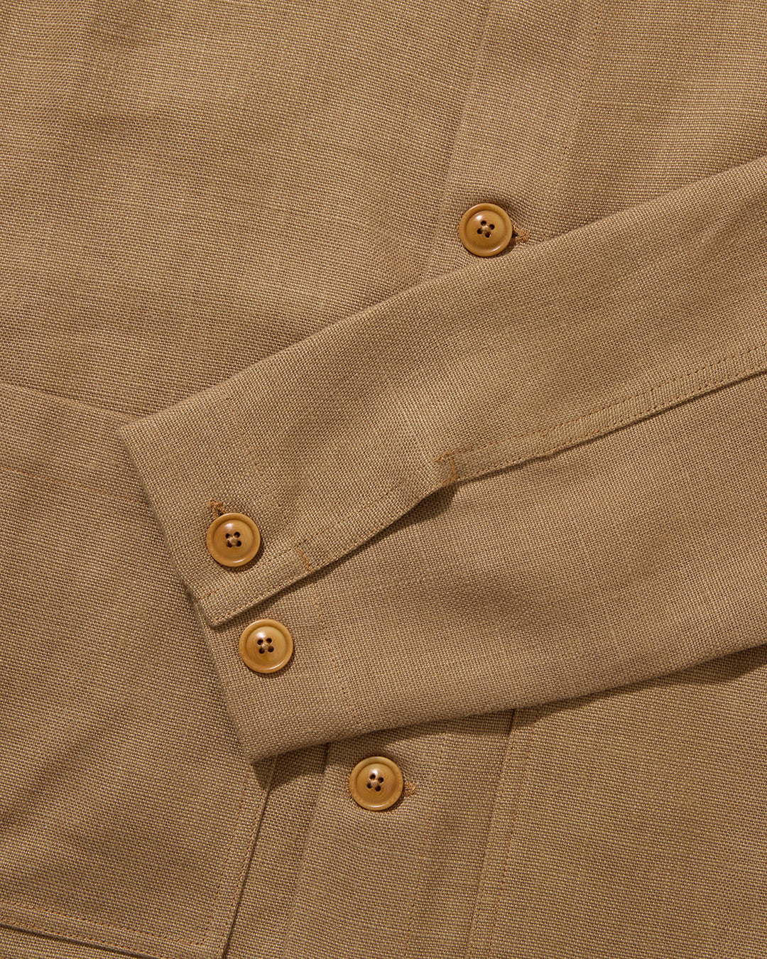 Close-up of a brown linen fabric with buttons on a garment