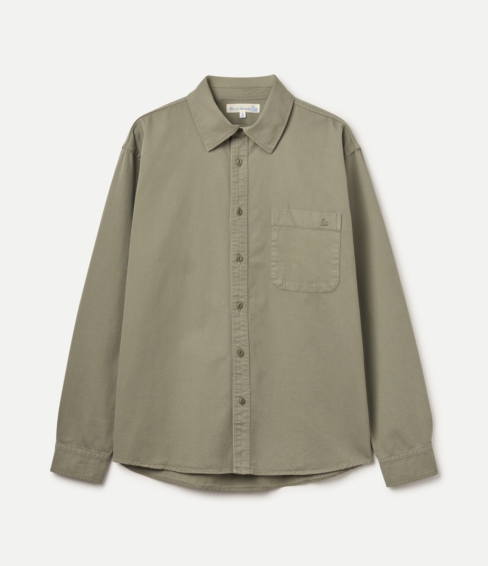 An olive green long-sleeve button-up shirt with herringbone structure and a single chest pocket, laid flat against a light off-white background.