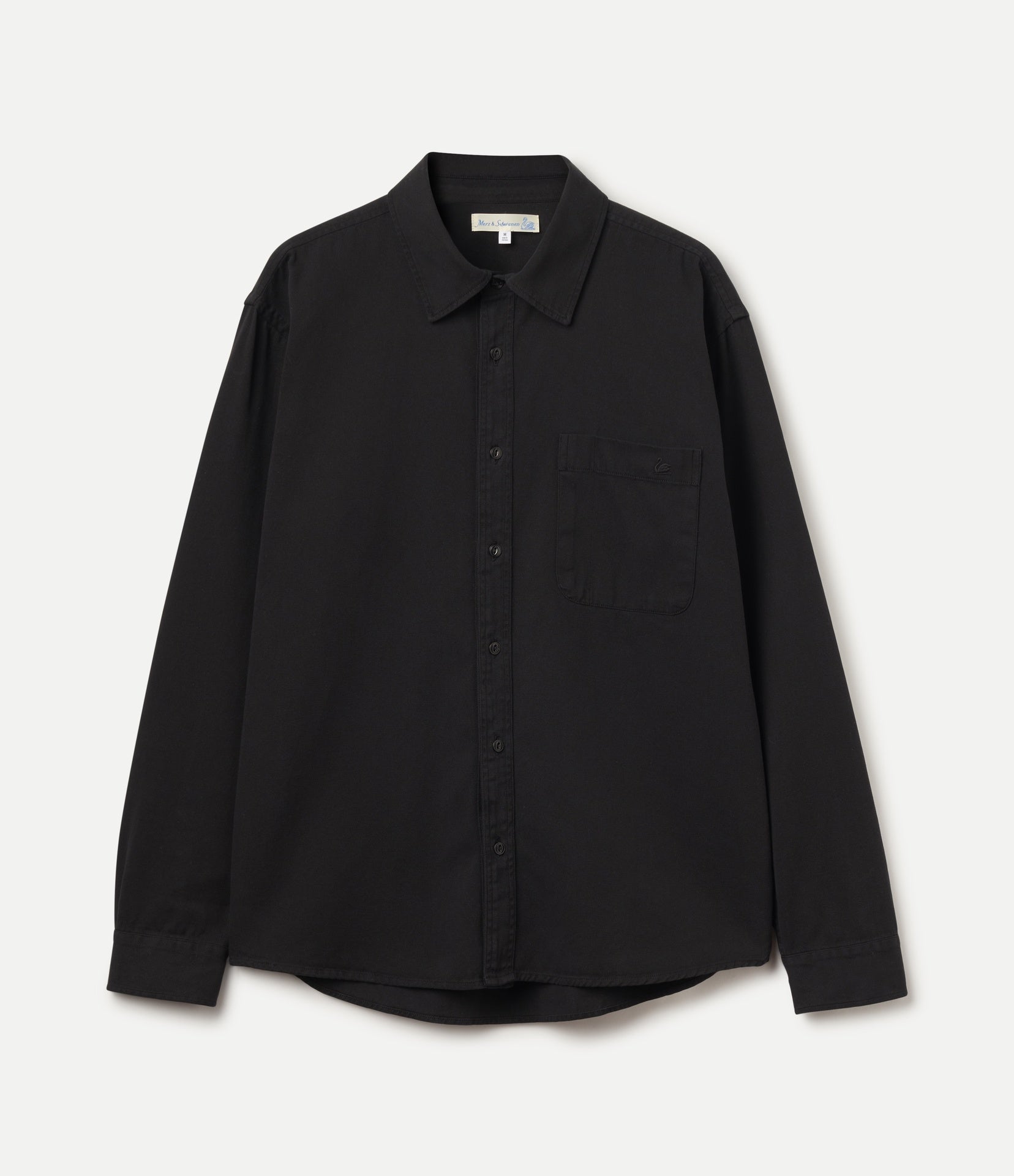 A black long-sleeve button-up shirt with a classic collar and a single chest pocket, displayed flat against a light off-white background.