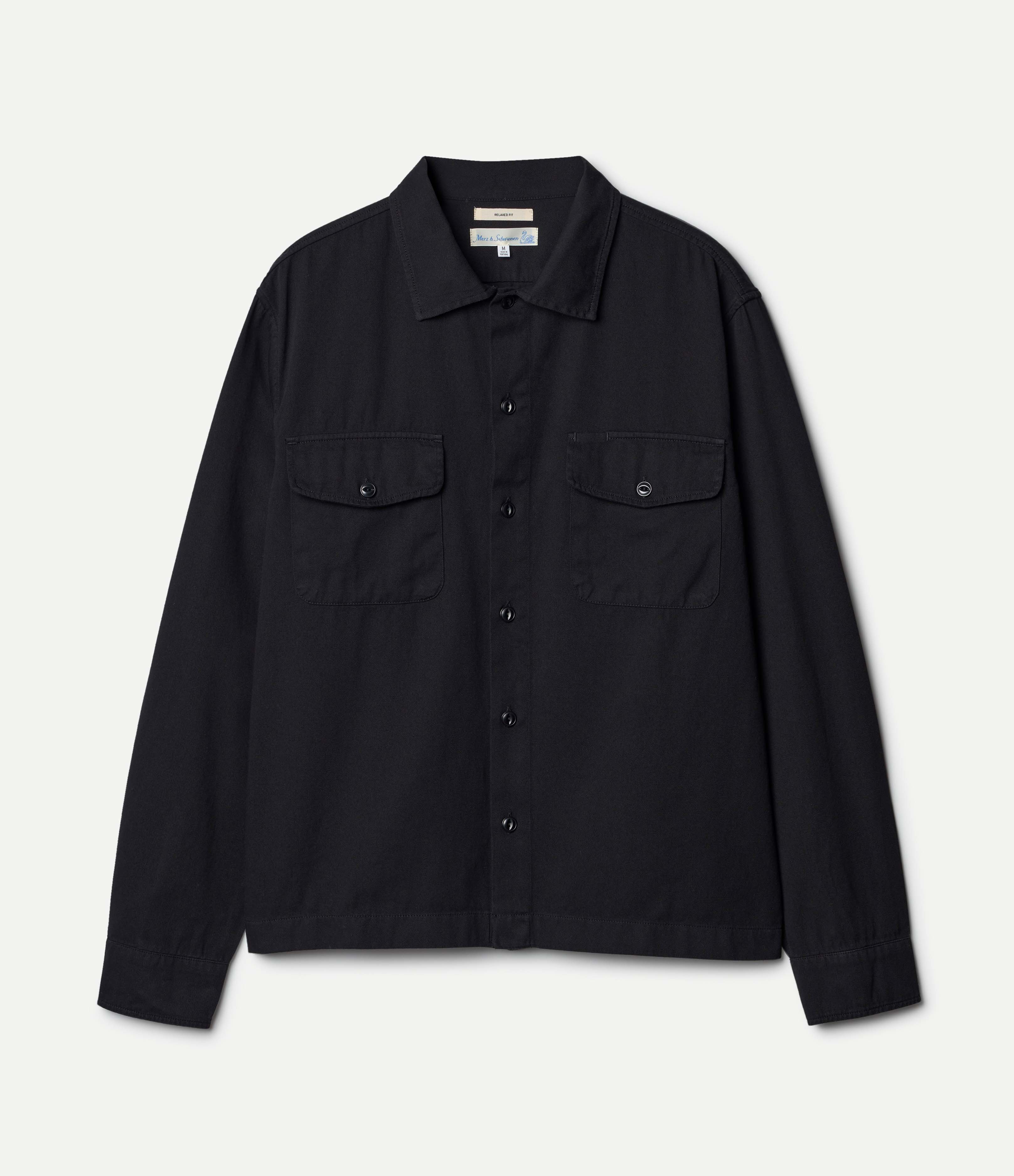 Black shirt with two front pockets on a light gray background