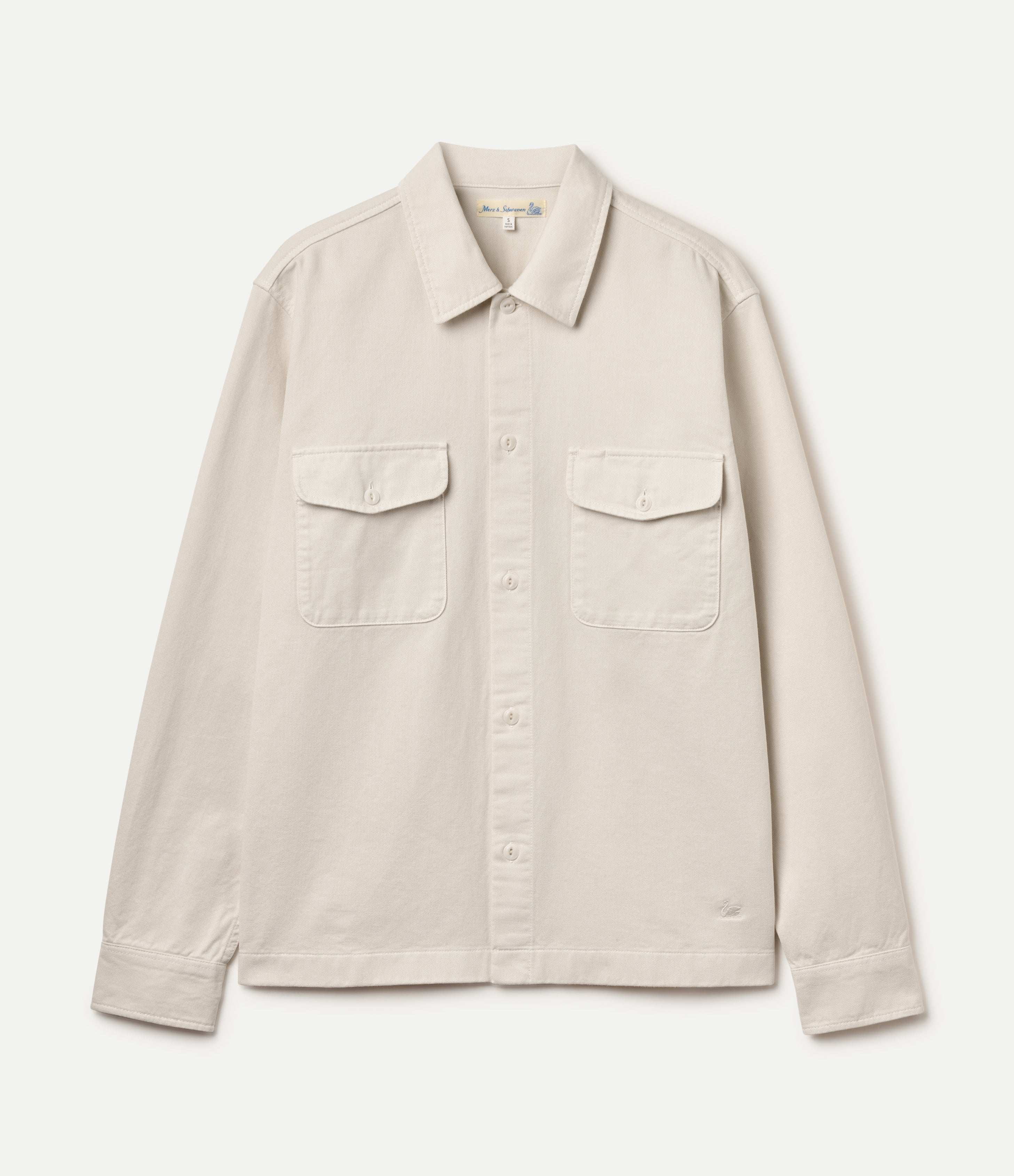 A light beige long-sleeve button-up  twill shirt jacket with two flap chest pockets, displayed flat against a light gray background.