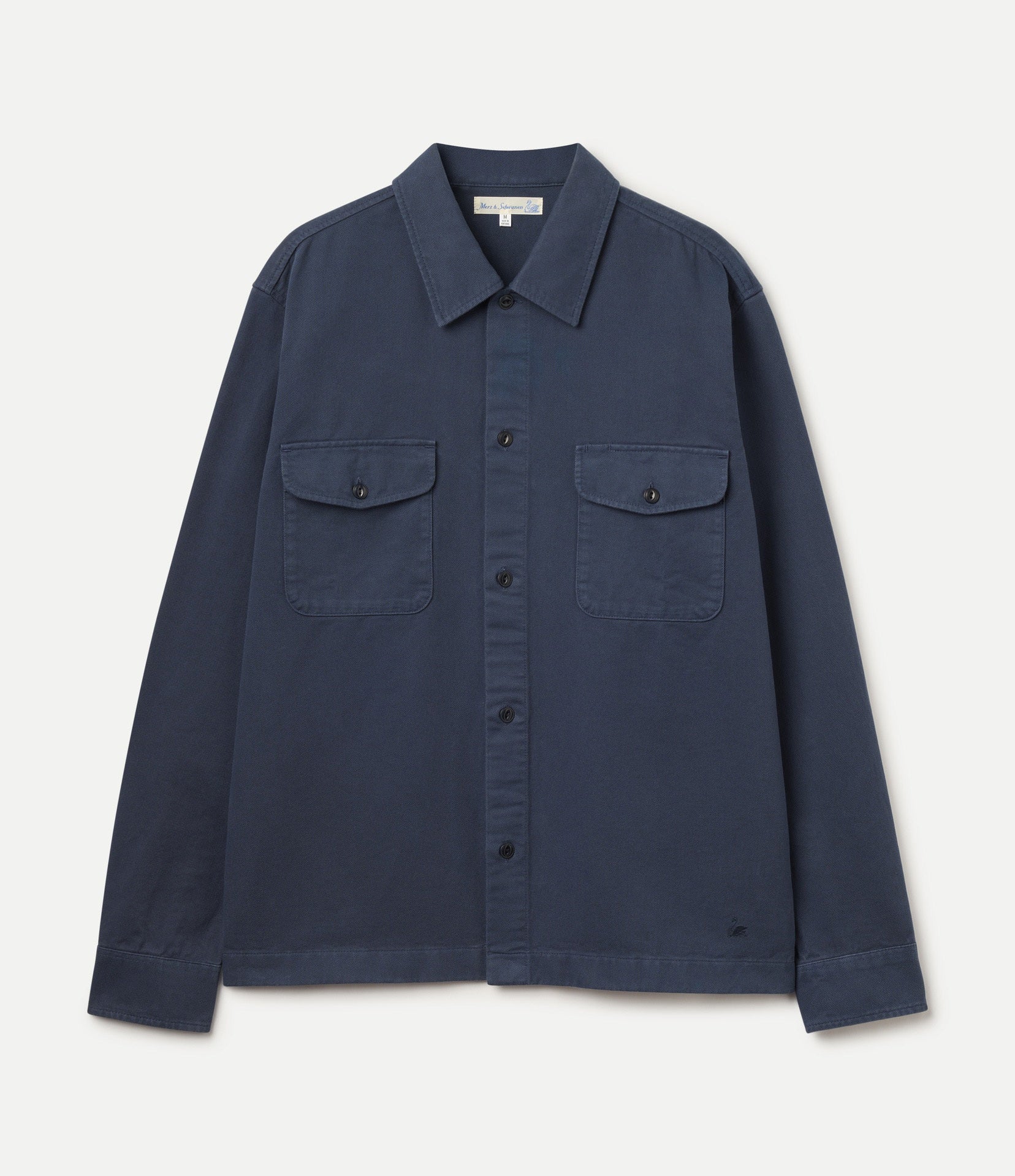 A dark navy blue long-sleeve button-up twill shirt jacket with two buttoned chest flap pockets, displayed flat against a light off-white background.