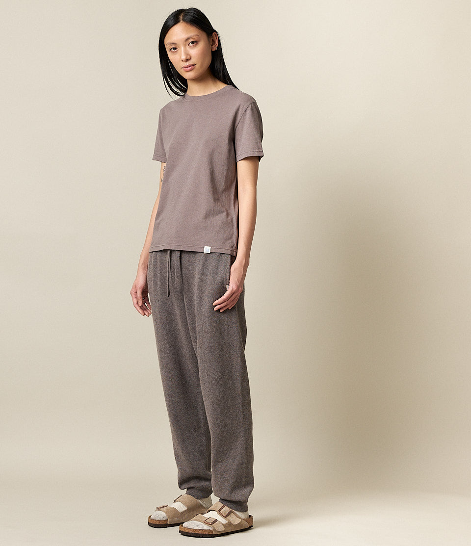 A model wearing gray drawstring pants and a matching top, standing against a neutral background.