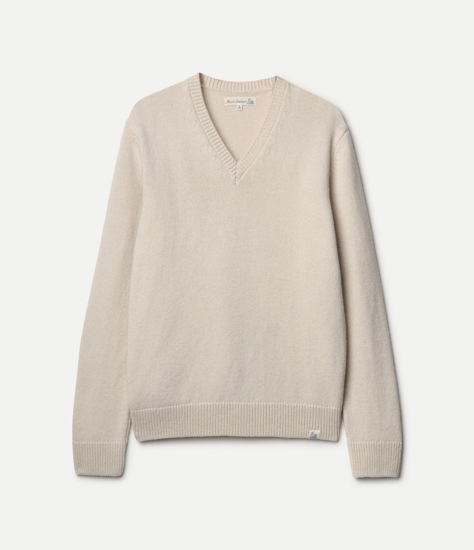 A light beige knit V-neck sweater with long sleeves, ribbed collar, cuffs, and hem, displayed flat against a light gray background.