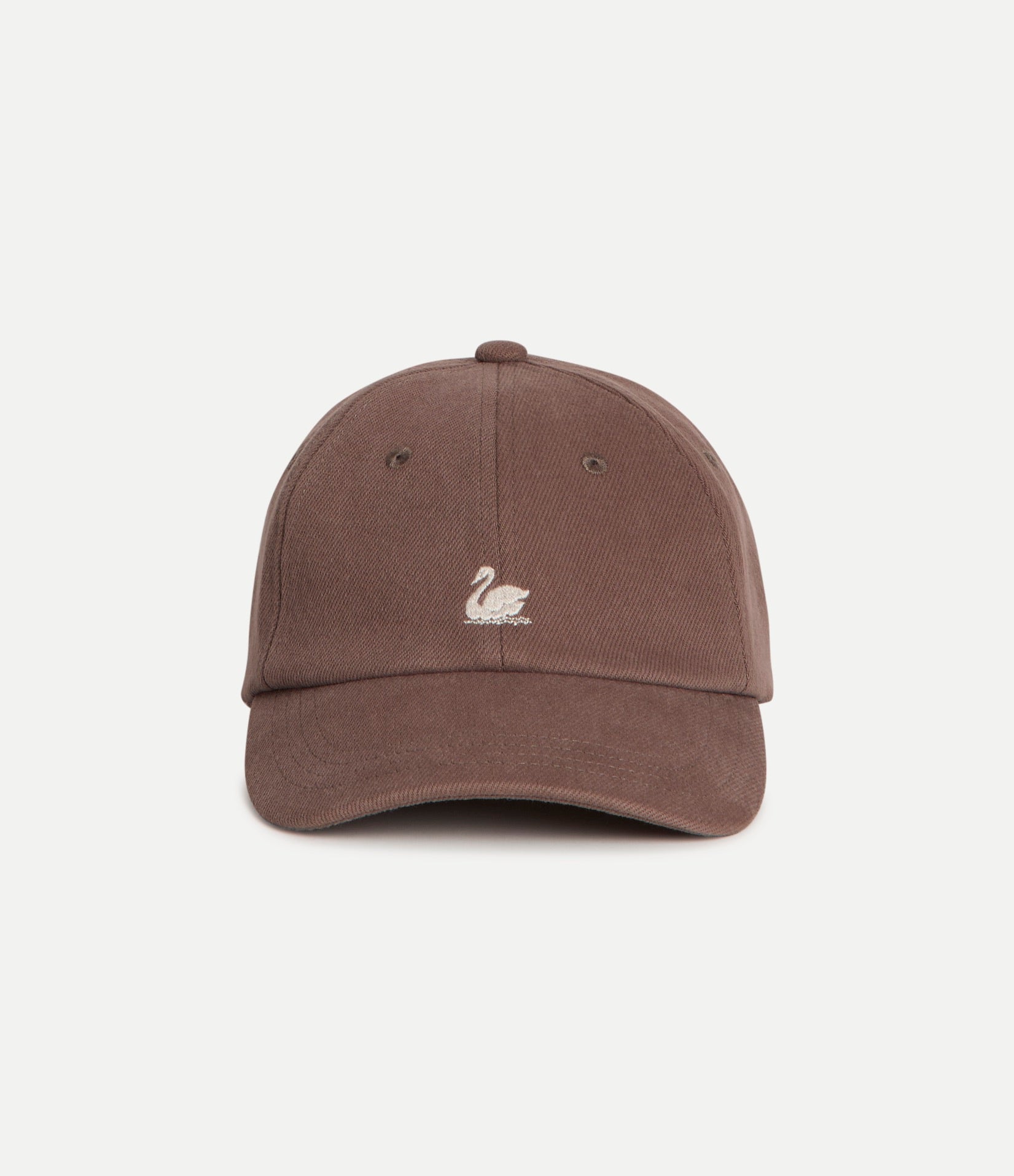A brown cotton baseball cap with a small white embroidered swan logo on the front, photographed against a clean off-white background.