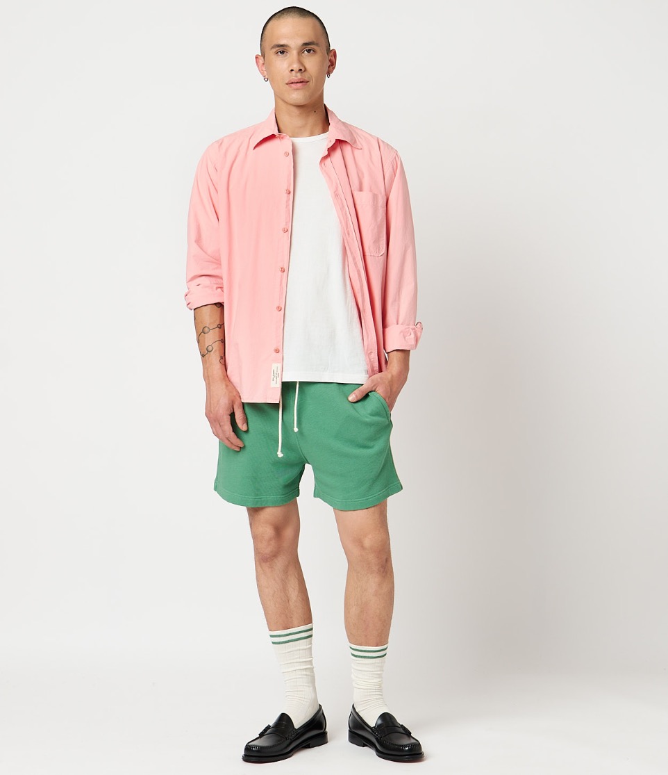 man wearing pink shirt green pants socks and loafers