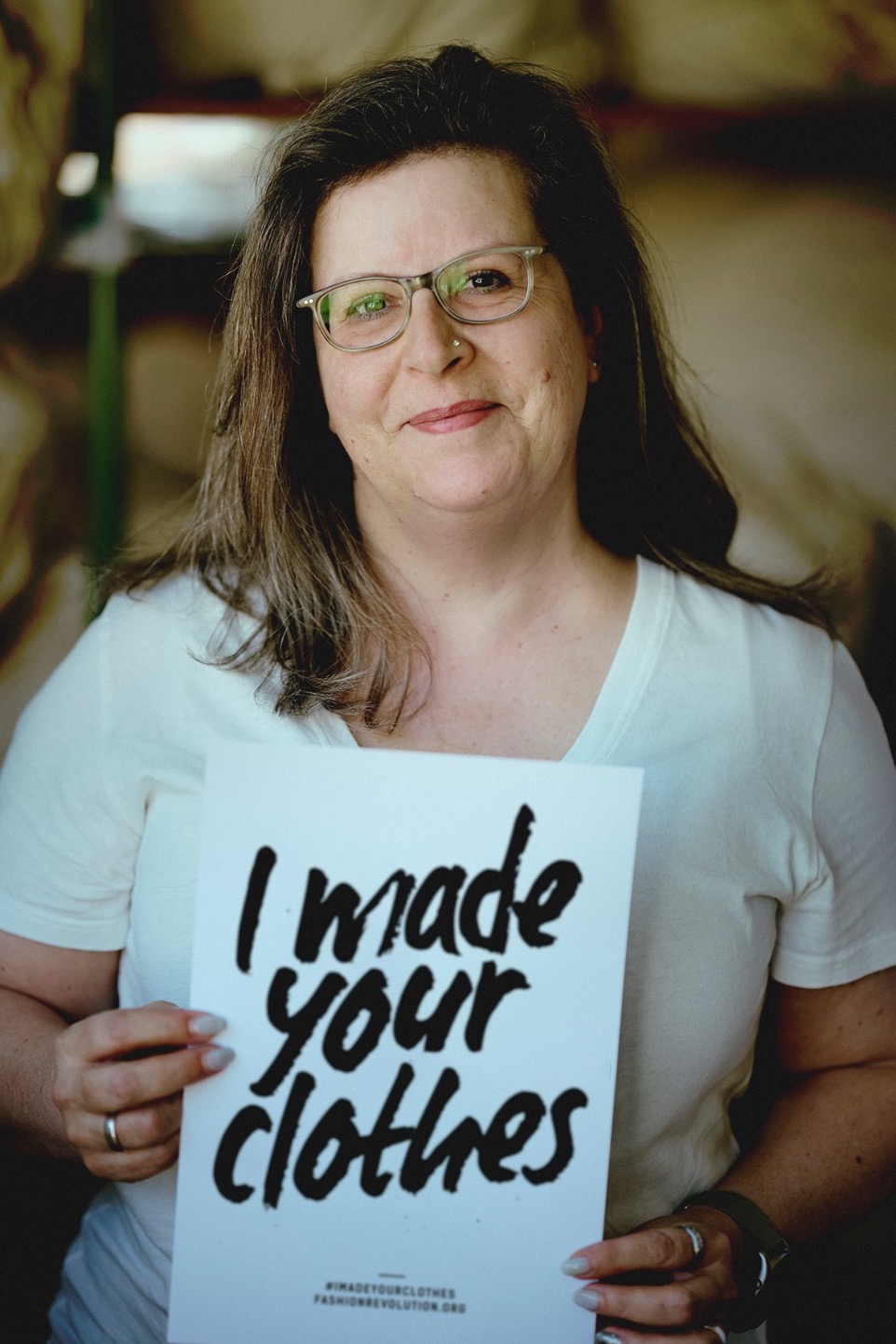 woman holding fashion revolution week sign