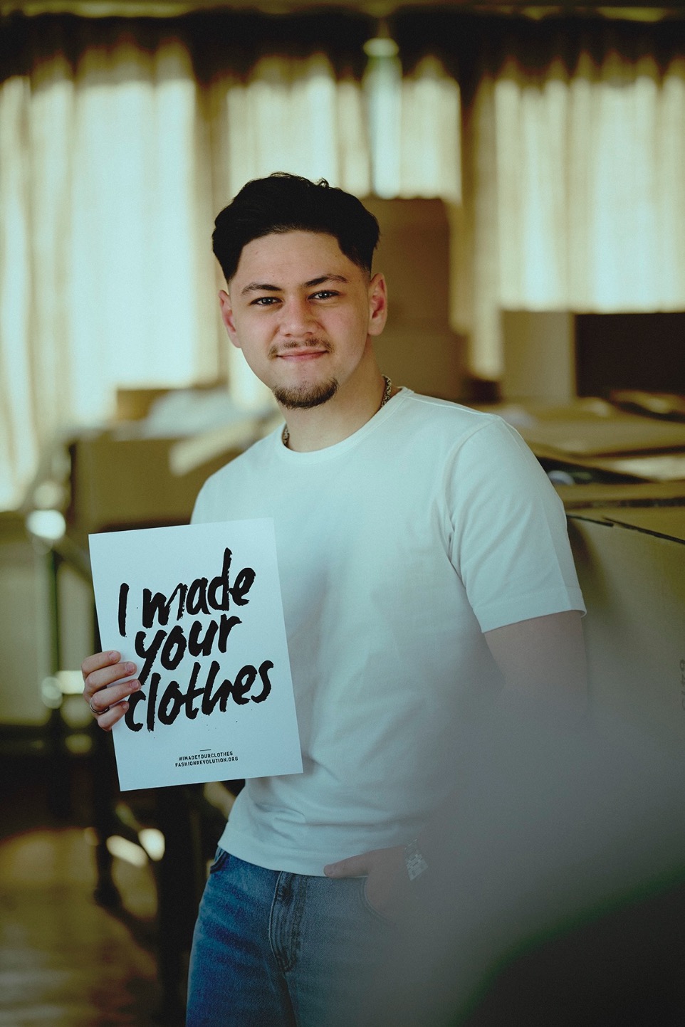 man holding fashion revolution week sign