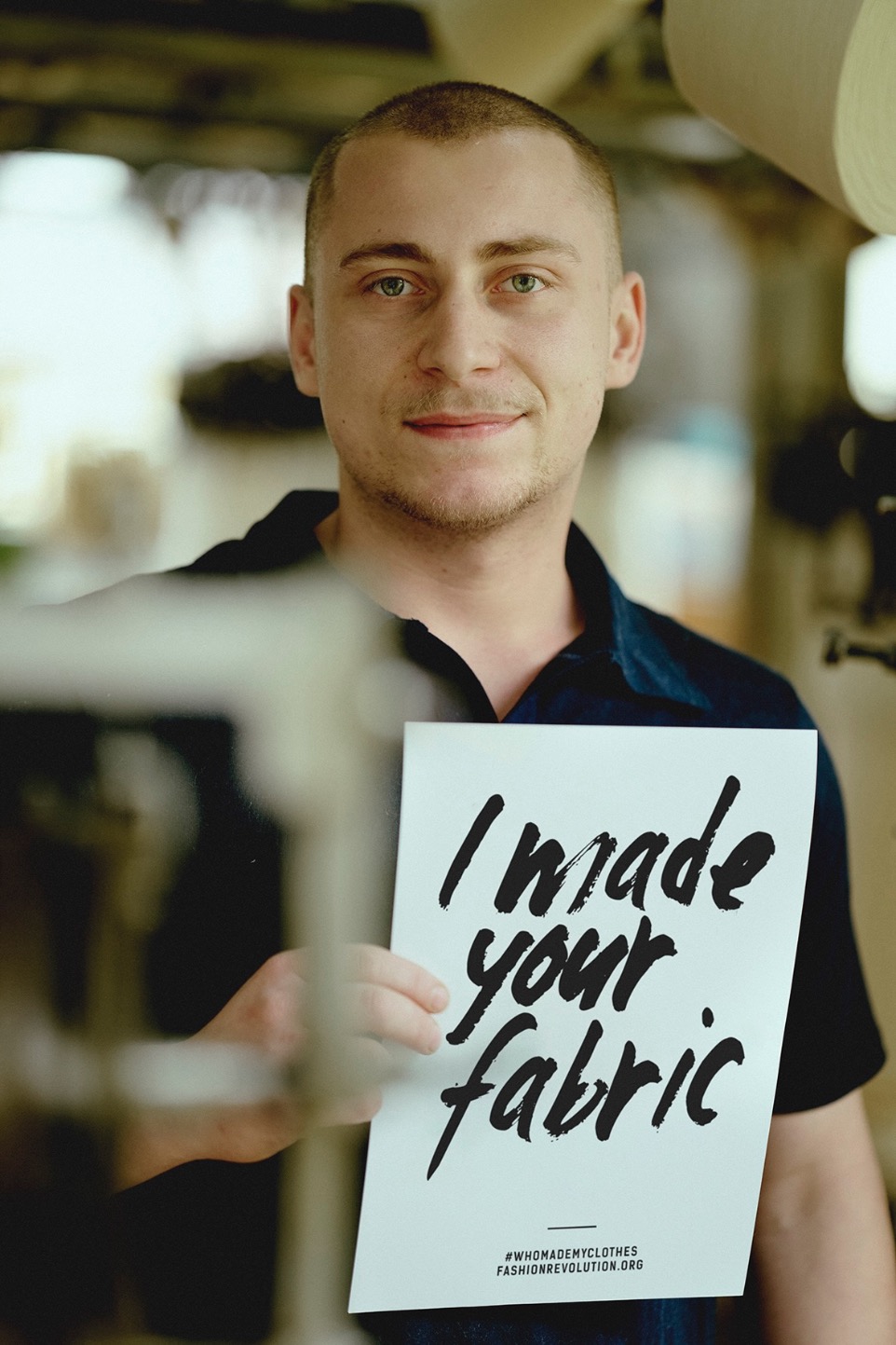 man holding fashion revolution week sign